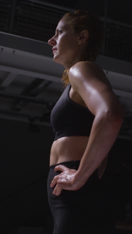 Vertical-Video-Shot-Of-Mature-Woman-Wearing-Gym-Fitness-Clothing-Sweating-Recovering-After-Exercise